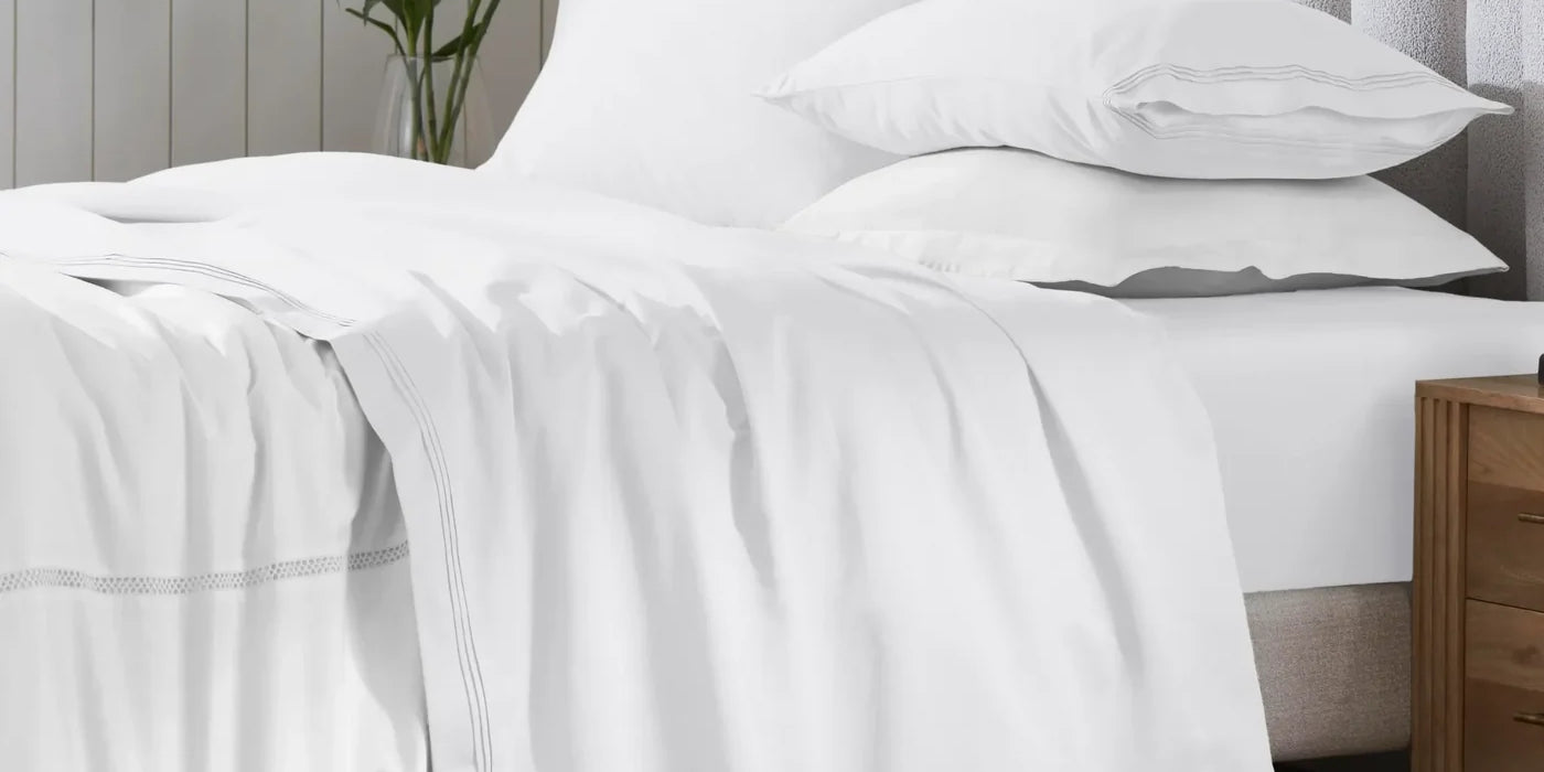 Superior 650 thread count Egyptian cotton sateen sheet set in white on a made bed
